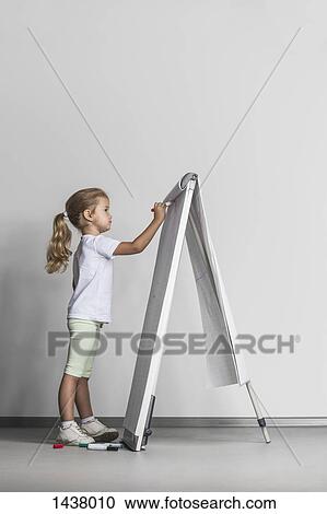 Side view of girl drawing on flipchart against white wall View Large Photo Image Stock Image - Side view of girl drawing on flipchart against white wall. Fotosearch