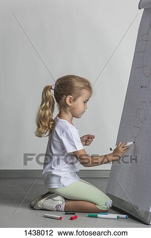Side view of girl kneeling while drawing on flipchart against white wall View Large Photo Image Stock Image - Side view of girl kneeling while drawing on flipchart against white wall. Fotosearch