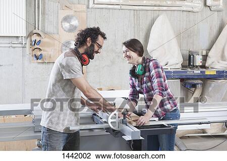 Side view of laughing coworkers using a sliding table saw in workshop View Large Photo Image Stock Image - Side view of laughing coworkers using a sliding table saw in workshop. Fotosearch