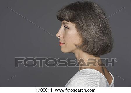Side view of mature woman with brown hair against gray background View Large Photo Image Stock Image - Side view of mature woman with brown hair against gray background. Fotosearch