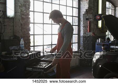 Side view of mechanic removing work tools from drawer at garage View Large Photo Image Stock Photography - Side view of mechanic removing work tools from drawer at garage. Fotosearch