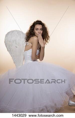 Side view portrait of bride in angel wings blowing kiss against colored background View Large Photo Image Stock Photo - Side view portrait of bride in angel wings blowing kiss against colored background. Fotosearch