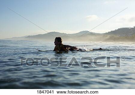 Silhouette boy surfer paddling out on sunny ocean, Sayulita, Nayarit, Mexico View Large Photo Image Stock Image - Silhouette boy surfer paddling out on sunny ocean, Sayulita, Nayarit, Mexico. Fotosearch