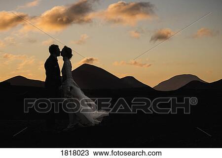 Silhouette bride and groom kissing at dusk with tranquil mountains in background View Large Photo Image Stock Image - Silhouette bride and groom kissing at dusk with tranquil mountains in background. Fotosearch