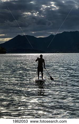 Silhouette man paddleboarding on sunny, idyllic lake, Walchensee, Bavaria, Germany View Large Photo Image Stock Image - Silhouette man paddleboarding on sunny, idyllic lake, Walchensee, Bavaria, Germany. Fotosearch