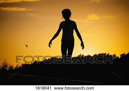 Silhouette woman standing against sunset sky View Large Photo Image Stock Image - Silhouette woman standing against sunset sky. Fotosearch