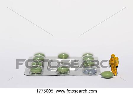 Small scientist in clean suit examining green pill from blister pack View Large Photo Image Stock Photography - Small scientist in clean suit examining green pill from blister pack. Fotosearch