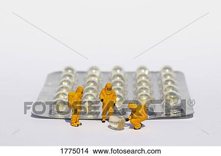 Small scientists in clean suits examining gel capsules from blister pack View Large Photo Image Picture - Small scientists in clean suits examining gel capsules from blister pack. Fotosearch