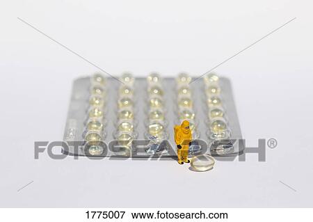 Small scientists in clean suits examining gel capsules from blister pack View Large Photo Image Stock Photo - Small scientists in clean suits examining gel capsules from blister pack. Fotosearch