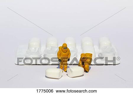 Small scientists in clean suits examining white tablet from blister pack View Large Photo Image Stock Photograph - Small scientists in clean suits examining white tablet from blister pack. Fotosearch