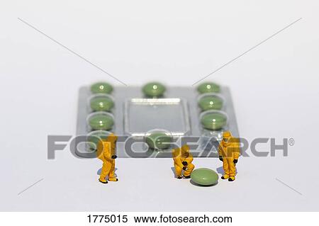 Small scientists in clean suits examining green pill from blister pack View Large Photo Image Stock Photography - Small scientists in clean suits examining green pill from blister pack. Fotosearch