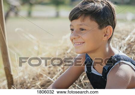 Smiling boy sitting in hay View Large Photo Image Stock Image - Smiling boy sitting in hay. Fotosearch