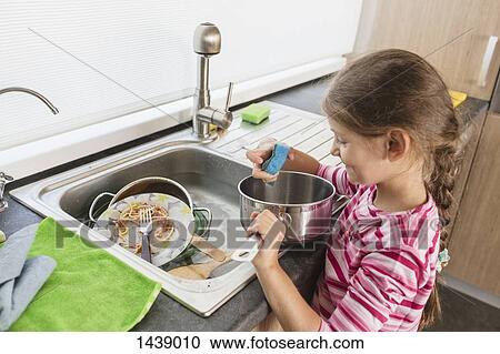 Smiling girl washing dishes at kitchen sink View Large Photo Image Stock Image - Smiling girl washing dishes at kitchen sink. Fotosearch
