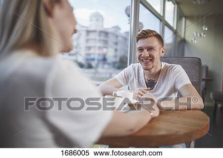 Smiling man sitting with girlfriend at restaurant View Large Photo Image Stock Photography - Smiling man sitting with girlfriend at restaurant. Fotosearch