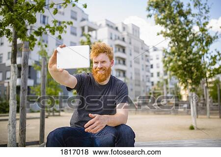 Smiling man with beard taking selfie with digital tablet in city View Large Photo Image Stock Photo - Smiling man with beard taking selfie with digital tablet in city. Fotosearch