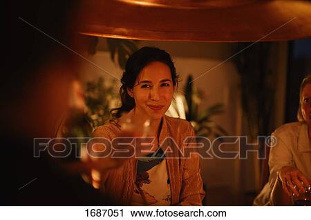 Smiling woman enjoying party with friend at home View Large Photo Image Stock Image - Smiling woman enjoying party with friend at home. Fotosearch