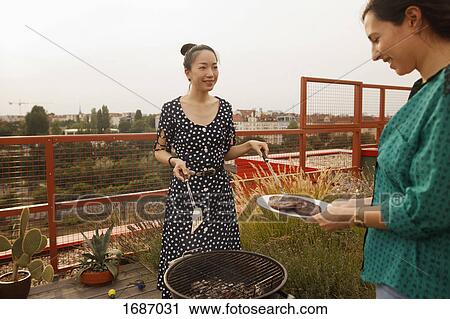 Smiling woman serving freshly grilled steak to female friend on patio View Large Photo Image Stock Image - Smiling woman serving freshly grilled steak to female friend on patio. Fotosearch