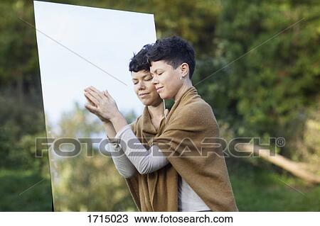 Smiling woman with closed eyes leaning on mirror while standing at park View Large Photo Image Stock Image - Smiling woman with closed eyes leaning on mirror while standing at park. Fotosearch