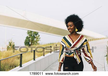 Smiling young woman walking View Large Photo Image Stock Image - Smiling young woman walking. Fotosearch