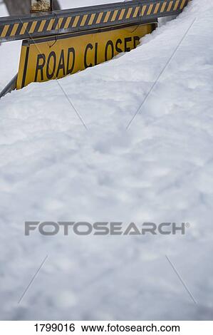 Stock Photograph - Snow covering Road Closed sign. Fotosearch