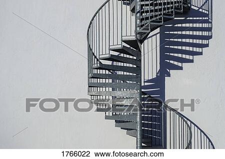 Spiral staircase along sunny wall View Large Photo Image Stock Image - Spiral staircase along sunny wall. Fotosearch