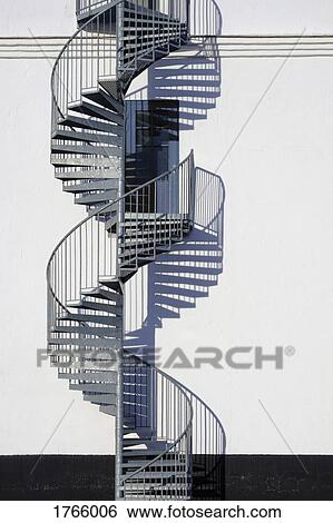 Spiral staircase and door along sunny wall View Large Photo Image Stock Photograph - Spiral staircase and door along sunny wall. Fotosearch