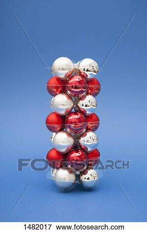 Stack of red and silver colored Christmas ornaments over blue background View Large Photo Image Stock Photo - Stack of red and silver colored Christmas ornaments over blue background. Fotosearch
