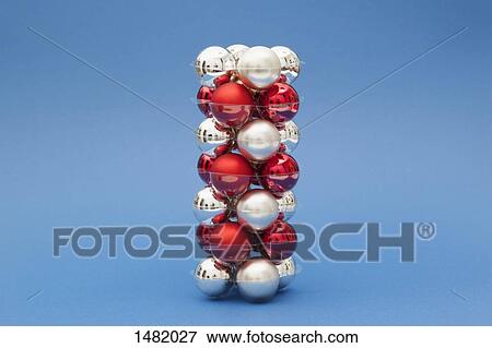 Stack of red and silver colored Christmas ornaments against blue background View Large Photo Image Stock Photo - Stack of red and silver colored Christmas ornaments against blue background. Fotosearch