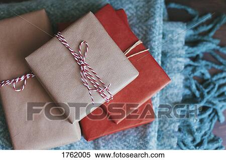 Stack of wrapped Christmas presents on a blanket View Large Photo Image Stock Photography - Stack of wrapped Christmas presents on a blanket. Fotosearch