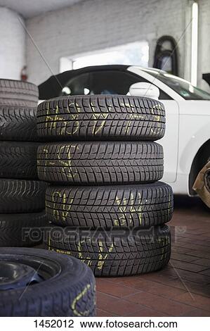Stacked tires by car in garage View Large Photo Image Stock Image - Stacked tires by car in garage. Fotosearch