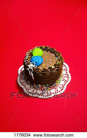 Still life chocolate birthday cake on vibrant red background View Large Photo Image Picture - Still life chocolate birthday cake on vibrant red background. Fotosearch