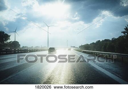 Sun reflecting on wet Autobahn Berliner Ring with wind turbines in distance, Berlin, Germany View Large Photo Image Stock Photograph - Sun reflecting on wet Autobahn Berliner Ring with wind turbines in distance, Berlin, Germany. Fotosearch