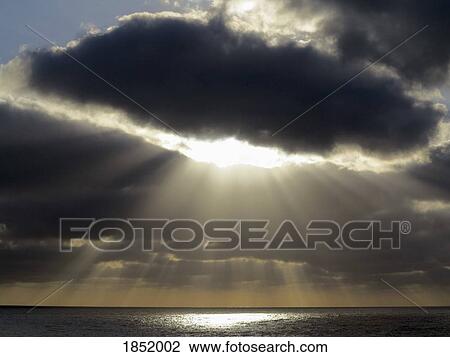 Stock Image - Sunbeams breaking through stormy sky over ocean, Santa Cruz de La Palma, Spain. Fotosearch