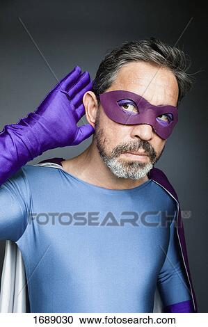 Superhero listening against gray background View Large Photo Image Stock Image - Superhero listening against gray background. Fotosearch