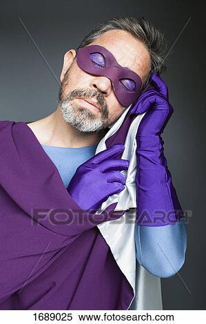 Stock Photography - Superhero sleeping with cape against gray background. Fotosearch