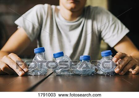 Teenage boy recycling plastic water bottles View Large Photo Image Stock Image - Teenage boy recycling plastic water bottles. Fotosearch
