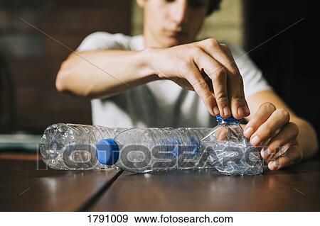 Teenage boy recycling water bottles View Large Photo Image Stock Photo - Teenage boy recycling water bottles. Fotosearch