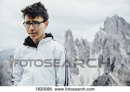Teenage boy standing at rugged mountain peaks, Drei Zinnen Nature Park, South Tyrol, Italy View Large Photo Image Stock Photography - Teenage boy standing at rugged mountain peaks, Drei Zinnen Nature Park, South Tyrol, Italy. Fotosearch