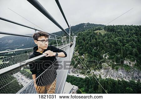 Teenage boy standing on Highline 179 suspension bridge, Tyrol, Austria View Large Photo Image Stock Image - Teenage boy standing on Highline 179 suspension bridge, Tyrol, Austria. Fotosearch