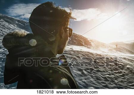 Teenage boy standing on sunny snow covered mountain, Reykjadalur, Iceland View Large Photo Image Stock Photo - Teenage boy standing on sunny snow covered mountain, Reykjadalur, Iceland. Fotosearch