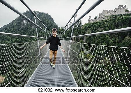 Teenage boy walking across Highline 179 suspension bridge, Tyrol, Austria View Large Photo Image Stock Image - Teenage boy walking across Highline 179 suspension bridge, Tyrol, Austria. Fotosearch