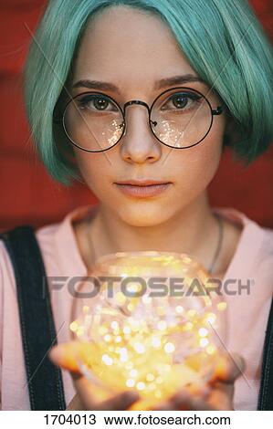 Teenage girl wearing eyeglasses holding illuminated string lights View Large Photo Image Stock Image - Teenage girl wearing eyeglasses holding illuminated string lights. Fotosearch