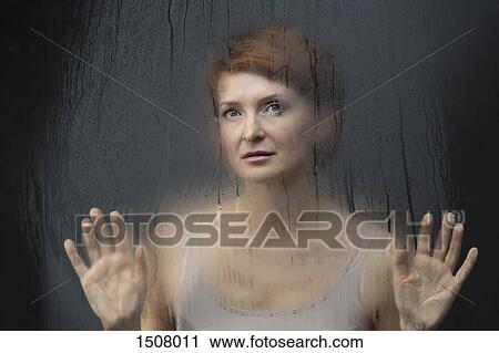 Thoughtful beautiful woman standing in front on condensed glass against black background View Large Photo Image Stock Image - Thoughtful beautiful woman standing in front on condensed glass against black background. Fotosearch