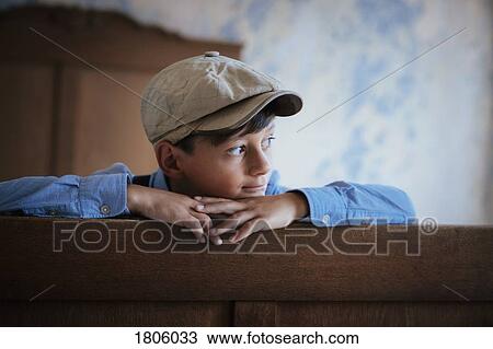 Thoughtful boy in cap looking away on bed View Large Photo Image Stock Image - Thoughtful boy in cap looking away on bed. Fotosearch
