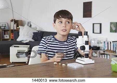 Thoughtful boy with microscope in living room at home View Large Photo Image Stock Image - Thoughtful boy with microscope in living room at home. Fotosearch