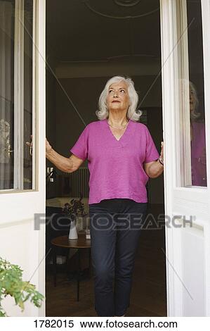 Thoughtful senior woman standing at patio doorway View Large Photo Image Stock Photography - Thoughtful senior woman standing at patio doorway. Fotosearch