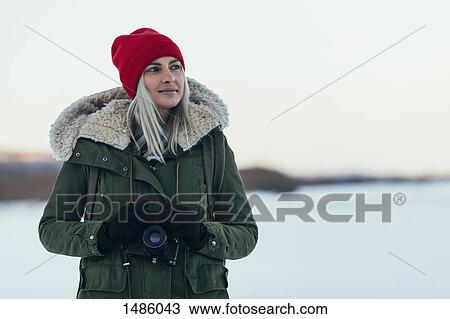Thoughtful woman with camera enjoying winter season View Large Photo Image Stock Image - Thoughtful woman with camera enjoying winter season. Fotosearch