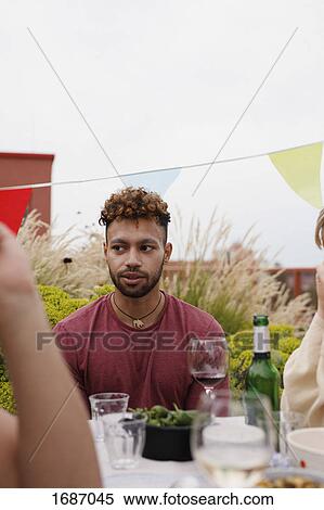 Thoughtful young man sitting at outdoor lunch table on patio against clear sky View Large Photo Image Stock Photography - Thoughtful young man sitting at outdoor lunch table on patio against clear sky. Fotosearch