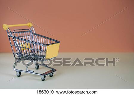 Stock Image - Tiny toy shopping cart. Fotosearch