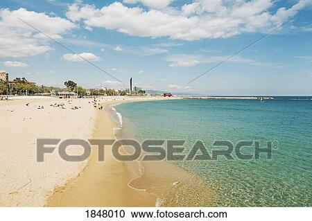 Stock Image - Tourists on sunny, summer beach, Platja de la Nova Icari, Barcelona, Spain. Fotosearch